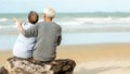 Asian Lifestyle senior couple hug and sitting on the beach happy in love romantic and relax time Royalty Free Stock Photo